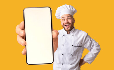 Happy chef man showing smartphone with white blank screen, recommending catering service or food...