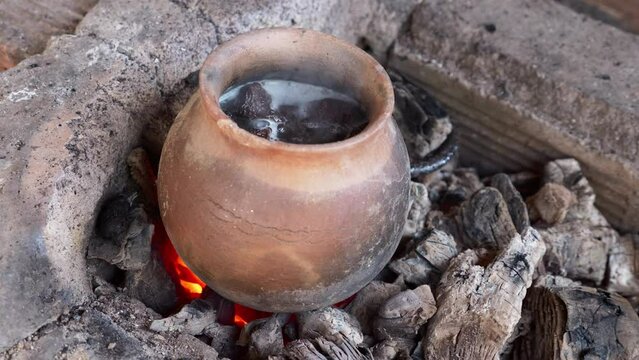 Water Chestnut boiling in Clay pot, traditional Fire pit, Rural Tay Nguyen. Vietnam