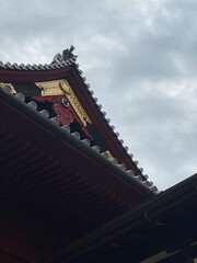 Fototapeta na wymiar The Japanese temple roof detail, golden emblem and gray roof kawaras, Ueno park Tokyo, Japan March 2022