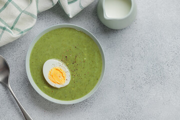 Spinach cream soup with boiled egg top view