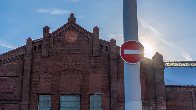 No entry sign in an old town with lens flare. Red no entry traffic sign on old building background.