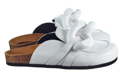 Slippers with an open heel, made of genuine leather, on a cork sole, decorated with large chain links isolated on a white background. Side view. Fashionable shoes.