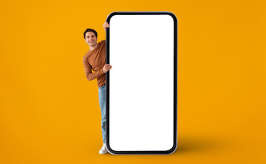 Handsome Young Man Peeking Out Of Behind Big Blank Smartphone