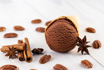 Chocolate ice cream with pecan, cinnamon and anise on a wooden table.