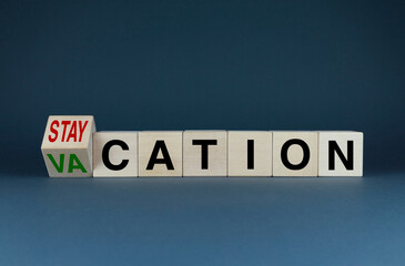 Cubes form the words Vacation or staycation. Concept of travel and vacation during a pandemic