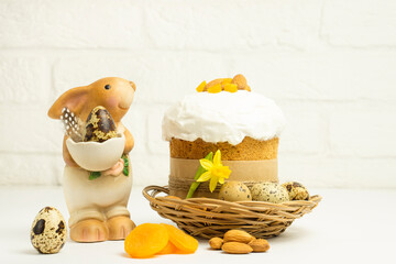 Easter bunny and Eastr cake   decorated with almonds  and candird fruits  on white background  with copy space . Happy Easter Holidays concept.