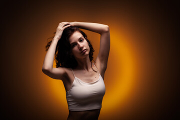 Beautiful teenage girl studio portrait on neon orange colored background..