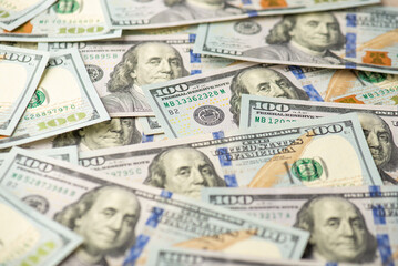 Photo of pile of one hundred dollar banknotes