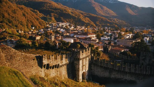 castle of bellinzona, ticino, switzerland at sunset with mountains and wine yards