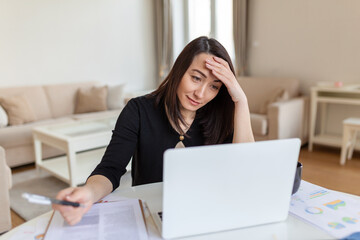 Asian woman working on laptop computer, smiling. Woman Working From Home On Laptop In Modern Apartment. Trendy woman working on laptop from home