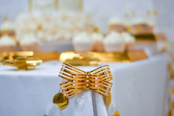 Decor on the corner of the table with sweets. Golden striped bow
