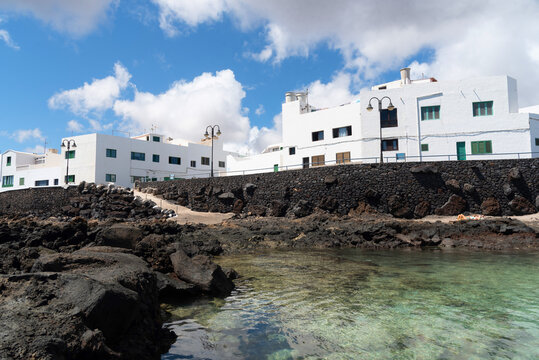 Piscina natural con agua transparente y las Casas Blancas tradicionales en la playa de punta mujeres Lanzarote en un d&iacute;a soleado con un cielo azul