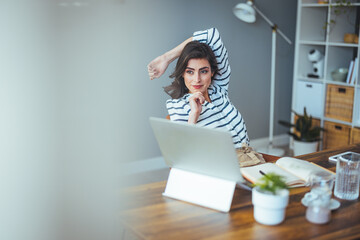 A beautiful business woman in casual clothes works on a virtual computer in the office desk. Small...