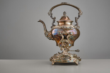 Fototapeta na wymiar Vintage teapot on a light background and gray table. Selective focus