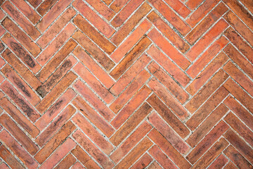 Old brown bricks tiled floor with zigzag pattern texture for background.