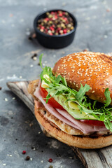 burger with ham, cheese, bacon, salad and vegetables. Big burger, american fast food. vertical image. top view. place for text