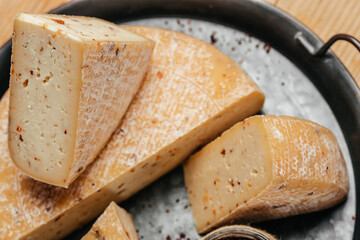 cheese with sun-dried tomatoes and mold. handicraft production. hard cheese delicious dairy products