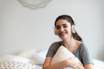 Naklejka premium young pretty woman person are happy and enjoy with music by using earphone for listen a sound audio in bedroom at home, relax and fun lifestyle with a song melody, house entertainment headset concept