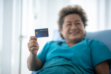old senior woman patient showing credit card for using in term of health insurance, concept of medical health care with business insurance credit concept
