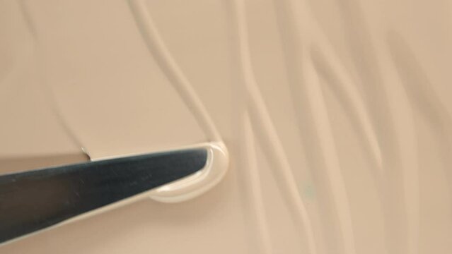 Foundation close-up, sliding cosmetic brush. Texture of foundation close-up. Advertising of decorative cosmetics. Beige paint.