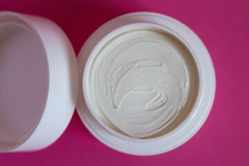 Cosmetic cream on pink background. Beauty and skin care theme