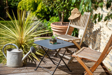 Petit jardin privé et charmant sur une terrasse en bois au printemps. - obrazy, fototapety, plakaty