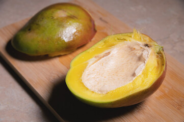 Close-up shallow depth of field cutaway mango kent on a cutting board. Mango home cooking