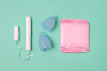 Different Types of Feminine Menstrual Hygiene Materials Products Such as Pads Cloths Tampons and Cups Top View Green Background