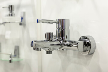 Shiny chrome faucet on the wall. Design and renovation. Close-up.