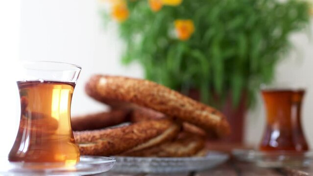 Turkish breakfast, turkish tea and simit, sesame bagel and potted plant on wooden table