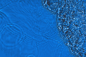 Transparent dark blue clear water surface texture with ripples, splashes. Abstract nature...