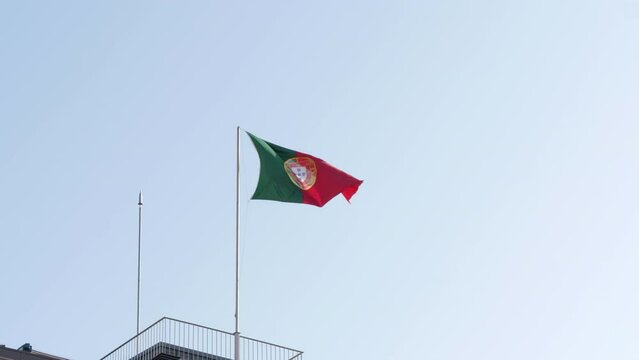 Portugal Flag On Pole Waving In The Wind Against Bright Blue Sky. - static