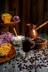 fresh coffee beans with coffee cup, classic metal coffee pot with homemade pudding on wooden plate for breakfast or snack