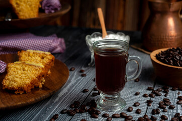 fresh coffee beans with coffee cup, classic metal coffee pot with homemade pudding on wooden plate for breakfast or snack