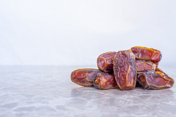 Stack of date fruits on marble table, space for text