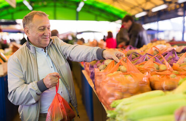 Middle aged man buying potatoes