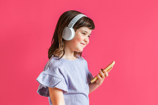 Joyful girl listening to music in headphones in studio