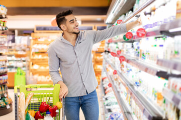 Arabic Man Taking Milk Bottle Shopping Groceries In Supermarket