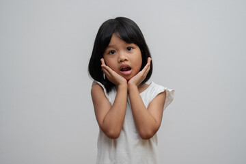 Portrait of Asian child 5 year old and to collect hair and Place her hands on her chin and make thinking pose on isolated white background, She is Happiness, radiance in youth, Education Concept