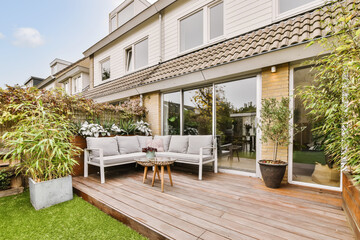 Terrace with couch and table near house