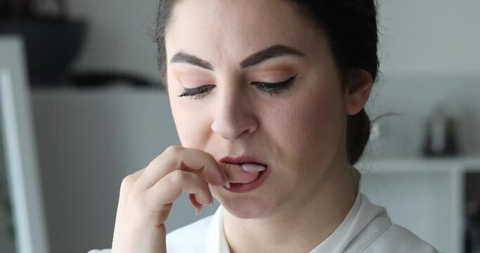 Girl biting her nails in a compulsive way