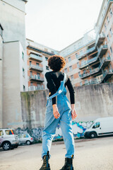 Back view young curly black afro hair woman walking away dancing spinning