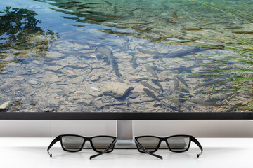 Classic glasses lie in front of the TV screen. Glasses for viewing a stereo image. Protective...