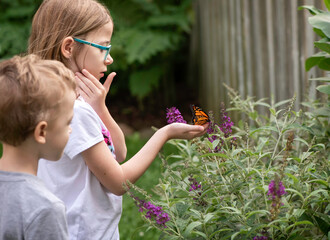 child releasing monarch butterfly