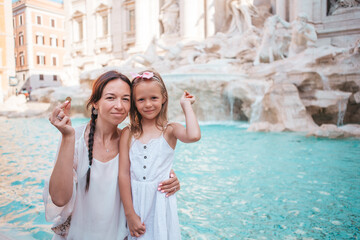 Young beautiful woman and little girl near fountain Fontana di Trevi - 495930079