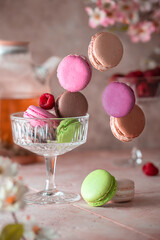 Tea time composition with colorful levitation macaroons. Background with small French cakes. Sweet and colorful French macaroons cakes