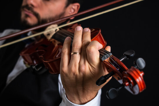 Hombre de vestimenta elegante tocando el viol&iacute;n