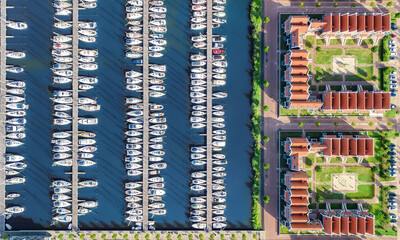 Aerial drone view of typical modern Dutch houses and marina in harbor from above, architecture of port of Volendam town, North Holland, Netherlands
