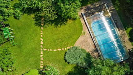 Swimming pool in beautiful garden aerial top view from above

