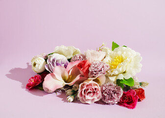 A floral composition made of colorful flowers. Purple, pink, white and yellow tones on purple background. Minimalist spring concept. Neat floral pattern. Copy space. Flat lay.